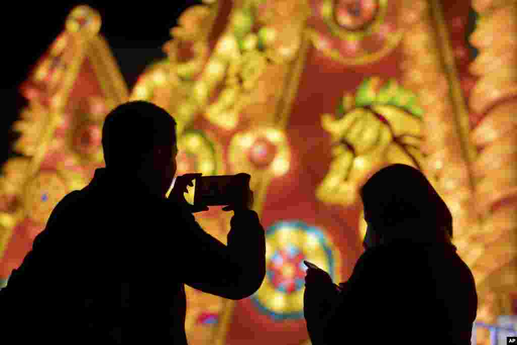 A visitor takes a smartphone photo of a lighted display celebrating the Lantern Festival at a park in Beijing. Saturday is the Lantern Festival in China, the final day of the annual celebration of the Chinese Lunar New Year.&nbsp;