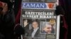 FILE - A copy of Zaman newspaper with a headline that reads "free journalists" is held during a protest against the detention of its editor-in-chief Ekrem Dumanli, Ankara, Dec. 17, 2014. 