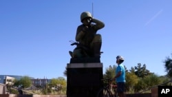 A visitor looks up at the Navajo Code Talkers Memorial on Veterans Day, Nov. 11, 2020, in Phoenix, Arizona. John Kinsel Sr., one of the last remaining Navajo Code Talkers who transmitted messages during World War II based on the tribe's native language, has died at 107.
