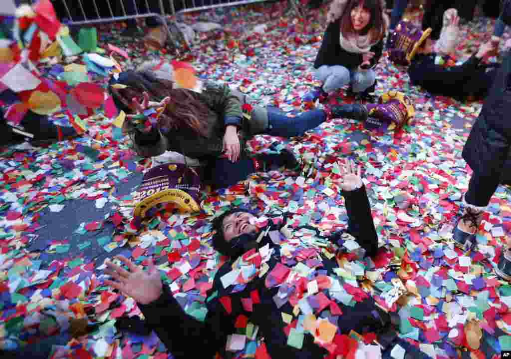 Revelers throw confetti on themselves after celebrating the new year in Times Square in New York.