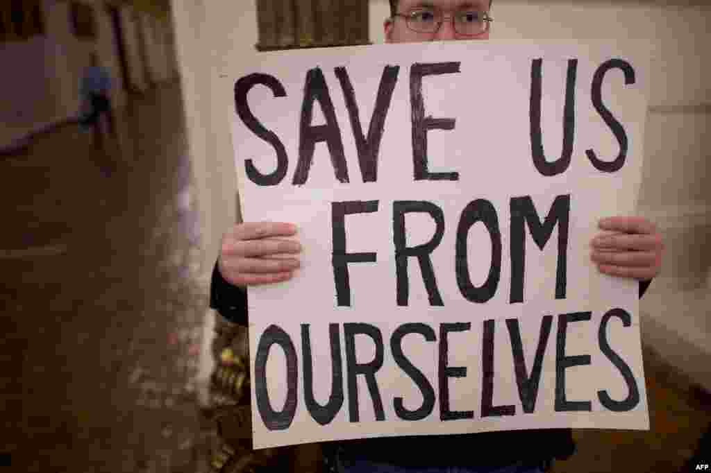 A Donald Trump protester joins demonstrators inside the Pennsylvania Capitol Building before electors arrive to cast their votes from the election in Harrisburg, Pennsylvania, Dec. 19, 2016.