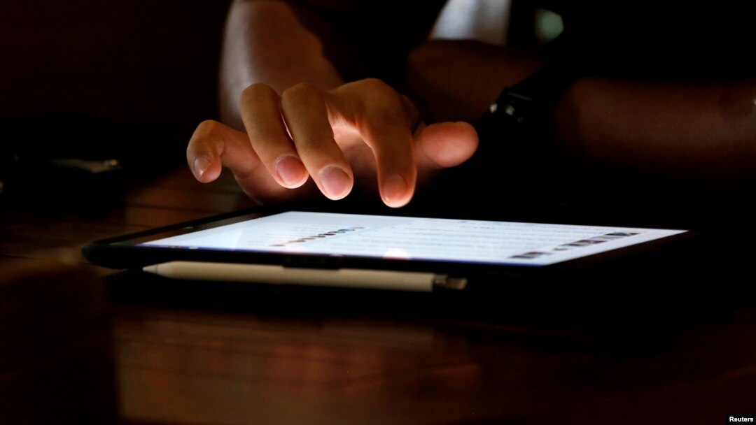 Một người đàn ông dùng Ipad tại một tiệm cà phê Internet tại Hà Nội, ngày 18/5/2021. 
