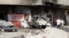 People inspect the scene of a car bomb attack in the Karrada neighborhood of Baghdad, Iraq, June 13, 2012.