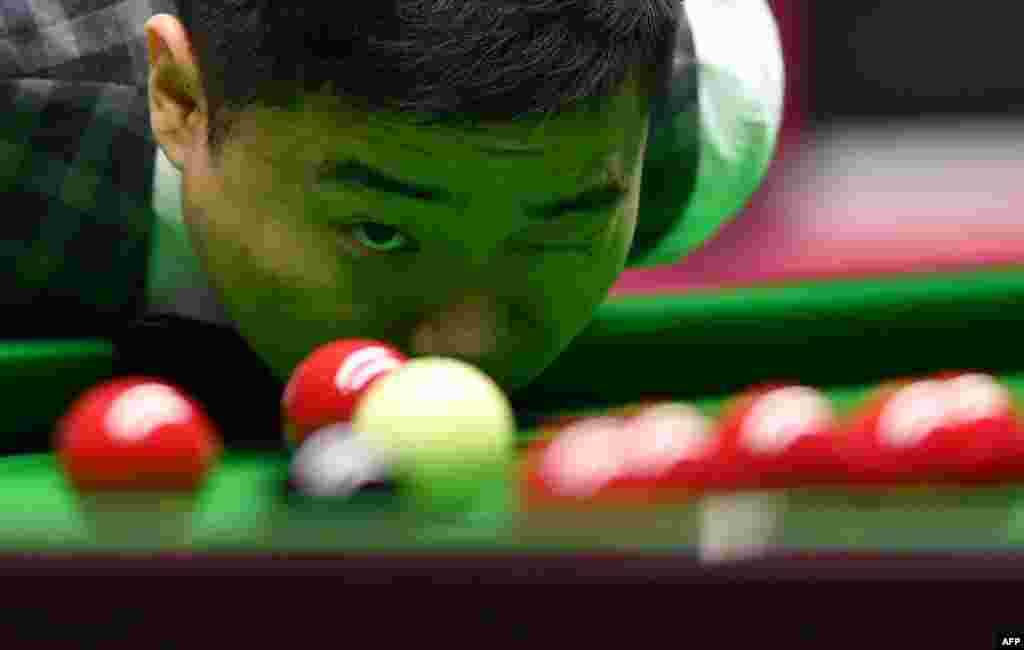 China's Ding Junhui prepares to play a shot during his quarter-final match against England's Joe Perry during the Masters Snooker tournament at Alexandra Palace in London.