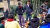 Refugees at Idomeni camp discuss their next moves; how best to get deeper into the European Union. (Jamie Dettmer for VOA) 