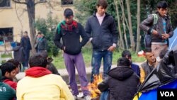 Refugees at Idomeni camp discuss their next moves; how best to get deeper into the European Union. (Jamie Dettmer for VOA) 
