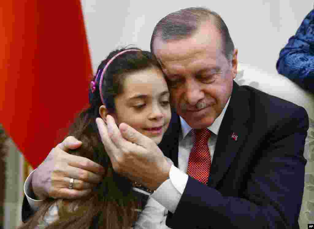 Turkey's President Recep Tayyip Erdogan, embraces Bana Al-Abed, 7, from Aleppo, Syria, at his Presidential Palace in Ankara. Tweets of life under siege in Aleppo by Bana went viral.