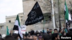Para pengunjuk rasa membawa bendera Al-Qaeda dalam demonstrasi anti-pemerintah setelah salat Jumat di Kota Marat Numan di Provinsi Idlib, Suriah, pada 11 Maret 2016.