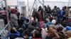 Migrants wait to cross the Greek-Macedonian border at a makeshift camp, near the village of Idomeni, Greece March 7, 2016.