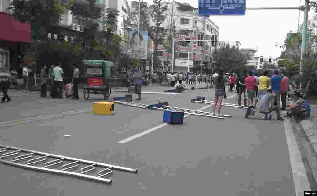 Torn up road dividers are placed on a street as roadblocks to prevent police from approaching in Shifang, Sichuan province, China, July 3, 2012.