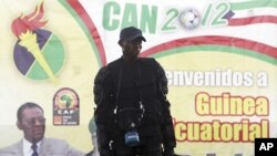 A member of Equatorial Guinea's police special forces stands in front of a banner of President Teodoro Obiang Nguema Mbasogo outside Estadio de Bata "Bata Stadium", which will host the opening match and ceremony for the African Nations Cup, in Bata Januar