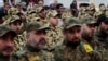 FILE - Hezbollah fighters listen to Hezbollah leader Sheik Hassan Nasrallah, as he speaks via a video link during a rally to mark the Hezbollah martyr day, in the southern suburb of Beirut, Lebanon.