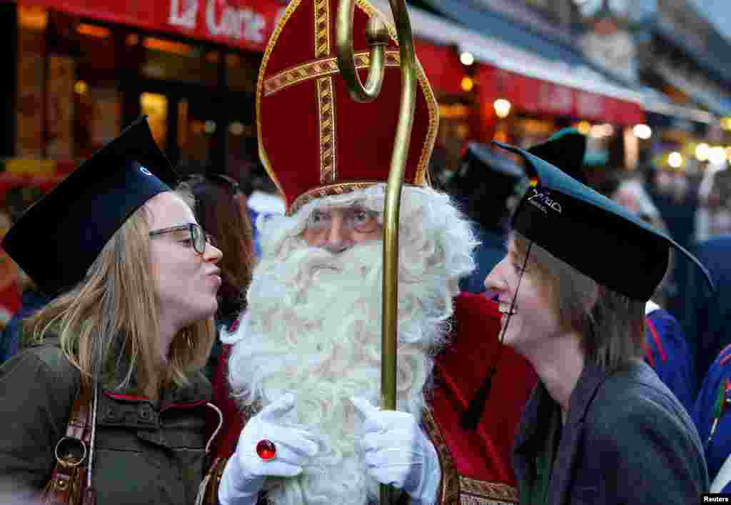 Saint Nicholas poses with students during a traditional parade in central Brussels, Belgium, Dec. 3, 2016.