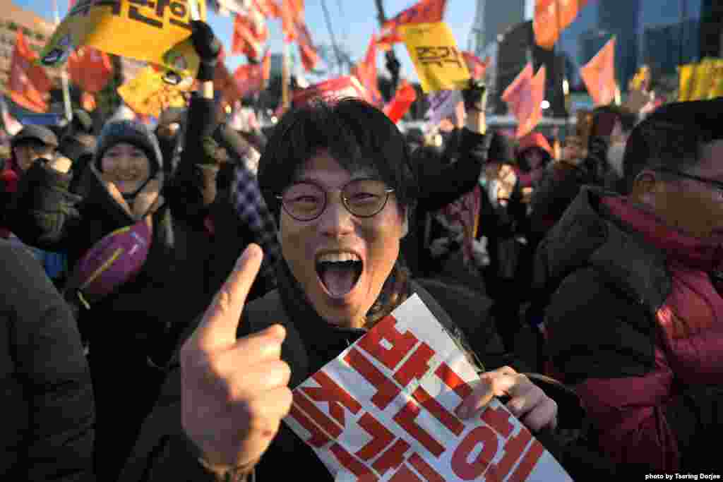 A protester reacts after the South Korean parliament's successful impeachment of President Park Geun-Hye as crowds gather outside the National Assembly in Seoul. Lawmakers began voting on an impeachment motion to strip the president of her sweeping executive powers over a corruption scandal that has paralyzed her administration and triggered massive street protests.
