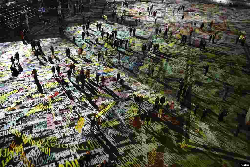 People walk over the laser installation "Time Drifts Cologne" before New Year celebrations for 2017 in Cologne, Germany, Dec. 31, 2016.