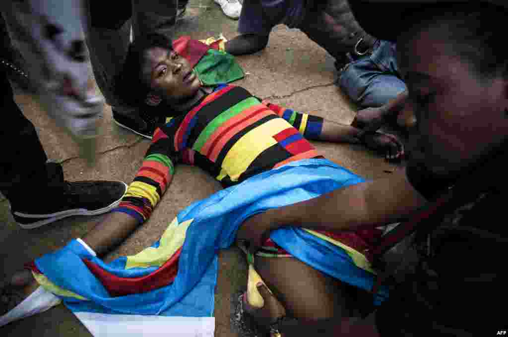 A Congolese protester lies on the ground after police opened fire with rubber bullets during a protest outside the Democratic Republic of the Congo's Embassy in defiance of their President, Joseph Kabila, in Pretoria, South Africa.