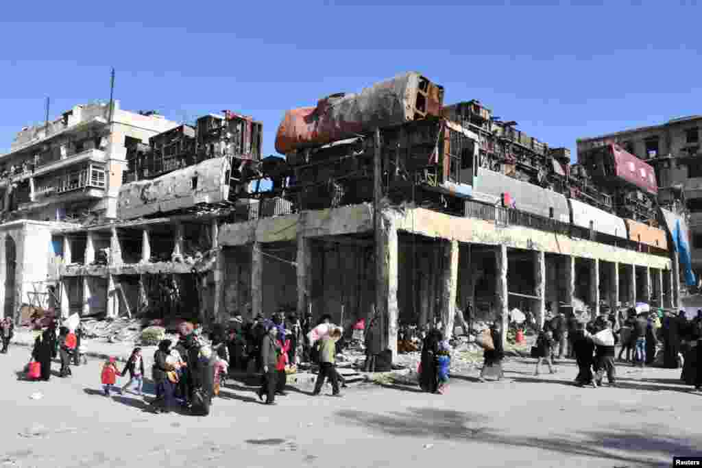 People who left the eastern districts of Aleppo carry their belongings as they walk in a government-held area of Aleppo, Syria.