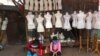 FILE - Women sit in front of mannequins at a textile market shuttered due to the coronavirus pandemic, in Jakarta, Indonesia, April 30, 2020. 
