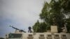A Ugandan police officer serving with the African Union Mission in Somalia's first Formed Police Unit stands at the top of an armored personnel carrier at a police station in the capital Mogadishu, August 7, 2012.