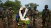 FILE - The relative of a woman that recently gave birth yesterday to twins holds one of the babies before departing towards Chad's border, escorted by troops from the African Union operation in CAR (MISCA) in the northern town of Kaga Bandoro.