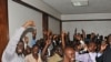 Uganda's top opposition leader Kizza Besigye, second left (A4C participant), waves to supporters inside the court in Kampala, Uganda after he was freed on bail, March 28, 2012. 