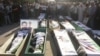 Syrian residents gather in front of the bodies of people, whom protesters say were killed by forces loyal to Syria's President Bashar al-Assad, during their funeral in Dara'a June 9, 2012. 
