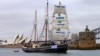 A supplied photo shows a tall ship displaying banners as it sails on Sydney Harbor in Australia, Sept. 8, 2018 as part of global climate change protests across 95 countries organized by the New York-based lobby group 350.org. 