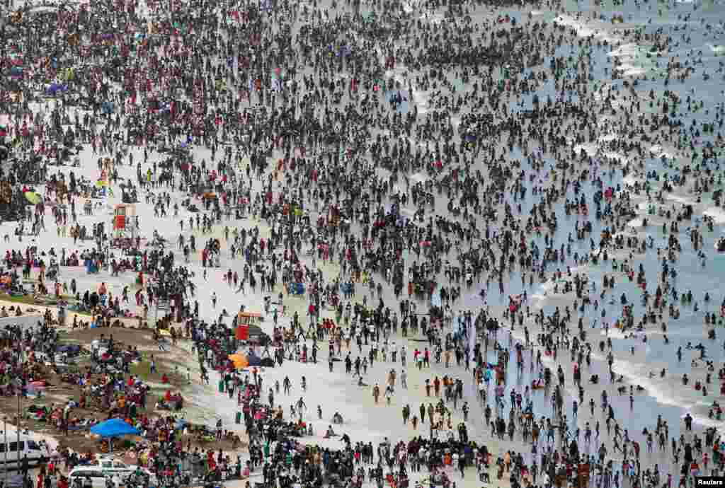 Crowds of revelers enjoy New Year's Day on a beach at Muizenberg in Cape Town, South Africa.