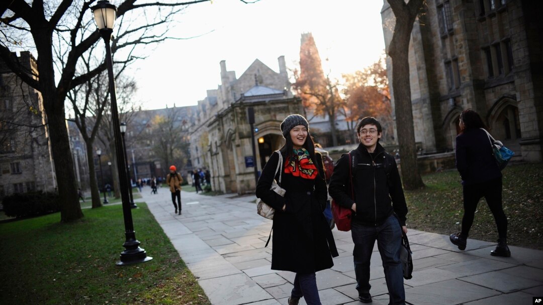 FILE - Yale University sophomore Yupei Guo, left, walks with friend Joseph Lachman on the school's campus in New Haven, Conn., In Nov. 20, 2014. With more undergraduates coming from overseas than ever, some Ivy League universities are reaching out in new 