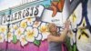 FILE - Street artist Lydia Emily Archibald, who was diagnosed with multiple sclerosis in 2012, touches up her mural aimed at raising awareness about the disease in Los Angeles, April 9, 2015.