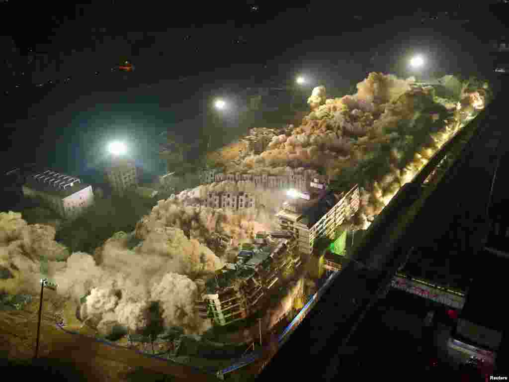 Buildings crumble during a controlled demolition in Wuhan, Hubei province, China, Jan. 21, 2017.