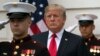President Donald Trump stands behind and in front of members of a Marine honor guard as he greets Canadian Prime Minister Justin Trudeau and Sophie Gregoire Trudeau as they arrive at the White House in Washington, Oct. 11, 2017.