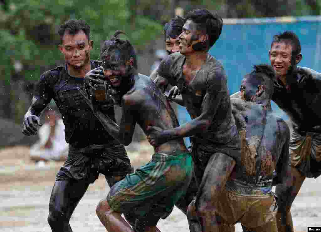 Men fight for an oiled coconut during a festival to mark Myanmar's 69th Independence Day in Yangon.