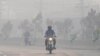 Commuters make their way amid smog in Lahore on Nov. 2, 2024. 