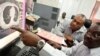 FILE - Clinical oncologists Dr. Joel Yarney (R) and Dr. Clement Edusa look at a scan of a cancer patient on a computer screen at the Korle Bu Teaching Hospital in Accra.