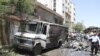 Residents and security personnel gather at the site of an explosion at al-Thawra street in Qudsiya suburb, near Damascus, in this handout released by Syria's national news agency SANA, June 8, 2012. 