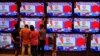 People watch Indian Prime Minister Narendra Modi address the nation amid concerns about the spread of COVID-19 on TV screens inside a showroom in Ahmedabad, March 19, 2020.