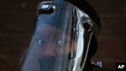 Omunye umuntu ozivikela kumkhuhlane weCOVID-19. (AP Photo/Denis Farrell)