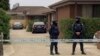 In this image made from video, police stand guard outside a raided property connected to a foiled terror attack, Nov. 20, 2018, in Melbourne, Australia. 