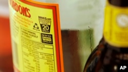 FILE - A label with a health warning is displayed on an alcoholic beverage bottle in Sydney, Australia, July 12, 2011.
