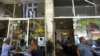People sit at a tavern at Plaka district in central Athens, Tuesday, June 19, 2012.