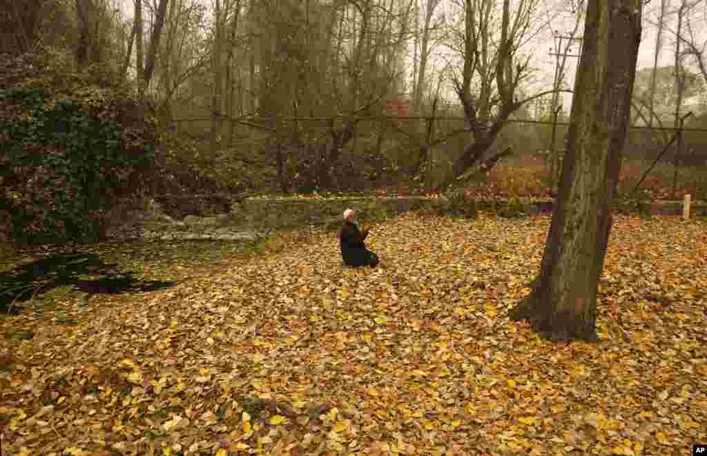 An elderly Kashmiri Muslim man prays on dried leaves on a cold and foggy day in Srinagar, Indian-controlled Kashmir.